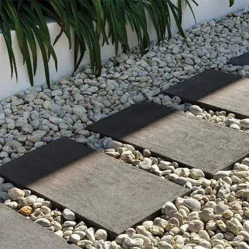 Reefstone Charcoal Stepping Stone Pavers surrounded by Pebbles - Edenstone | Australian Landscape Supplies