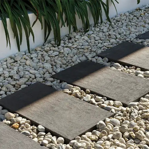 Reefstone Charcoal Stepping Stone Pavers surrounded by Pebbles - Edenstone | Australian Landscape Supplies