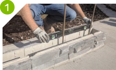 Man aligning the first layer of a Pentablock retaining wall